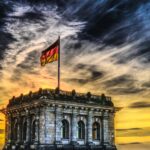 Flaga Niemiec na budynku na tle zachodzącego słońca